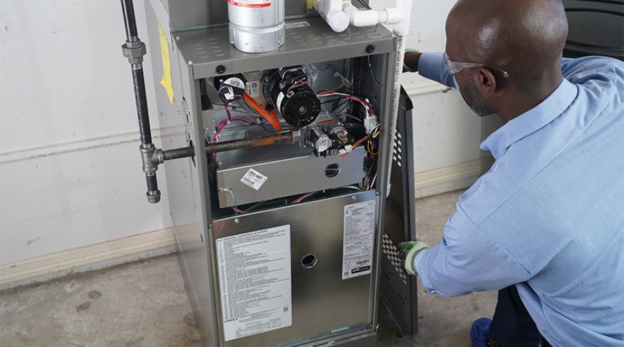 Technician inspecting an open furnace unit.